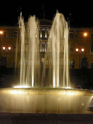 De fontein op het Syntagma Plein bij nacht met het Parlementsgebouw op de achtergrond